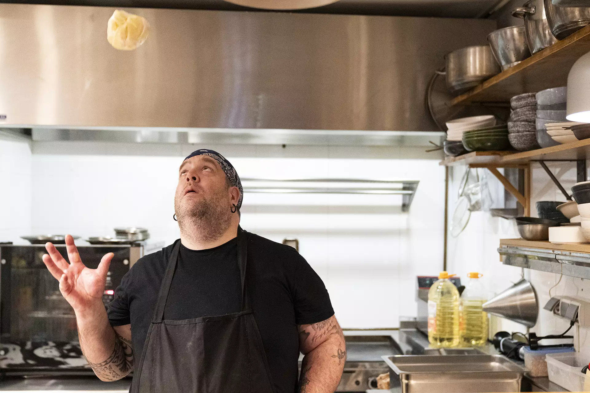 Luis, cocinero del restaurante lanzando al aire una masa