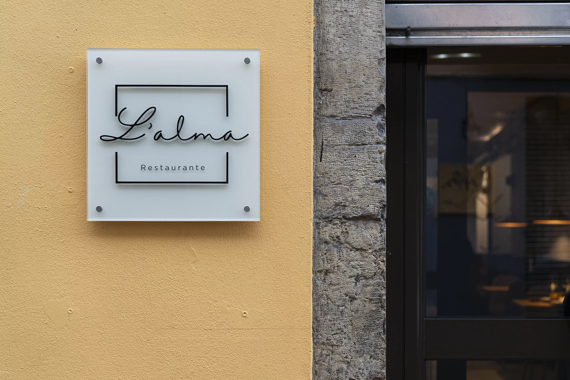 Cartel del restaurante con el logo junto a la puerta de entrada